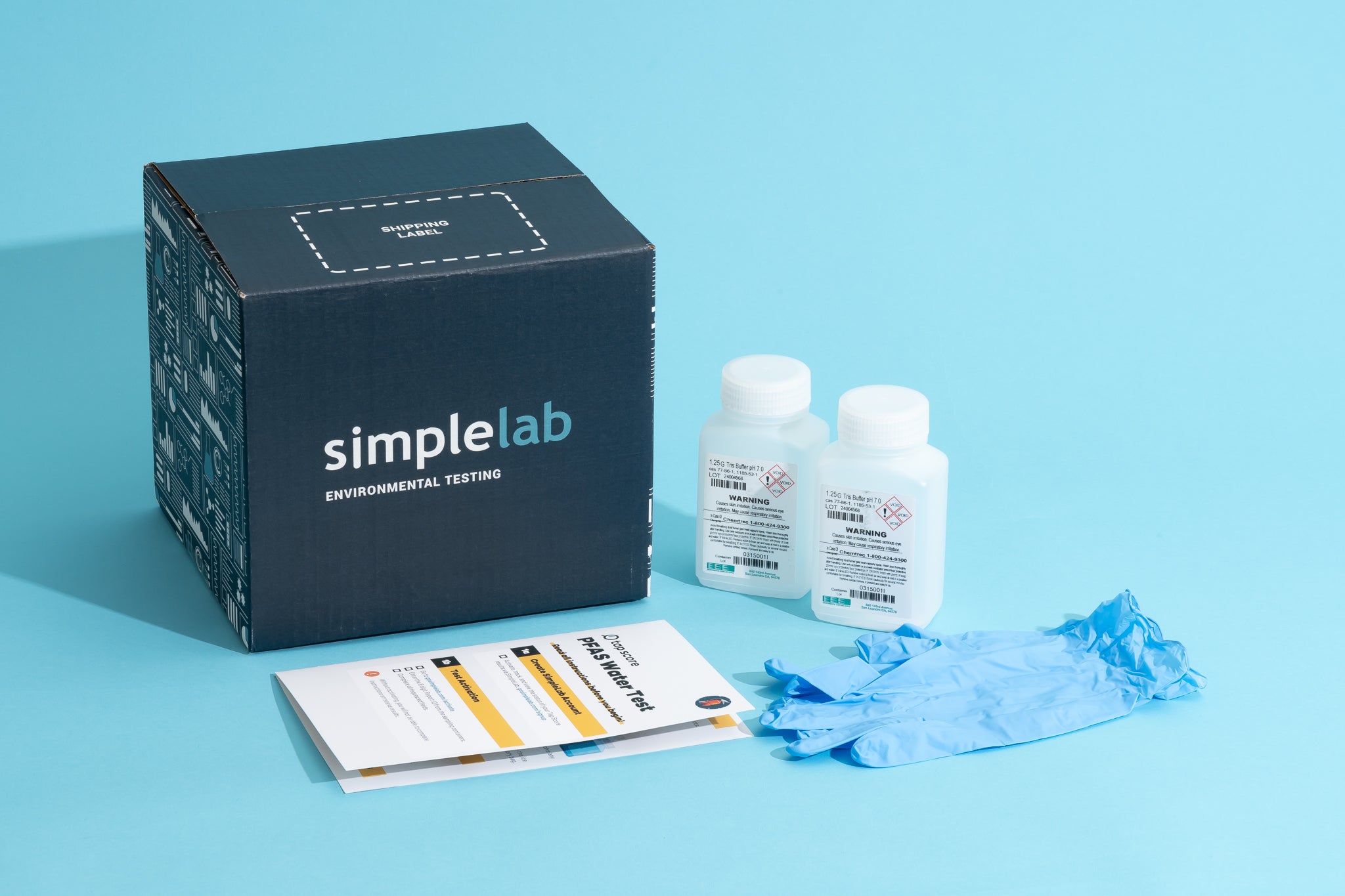 A SimpleLab environmental testing kit is displayed on a blue background, including a box, two bottles of testing solution, blue gloves, and an instruction pamphlet.