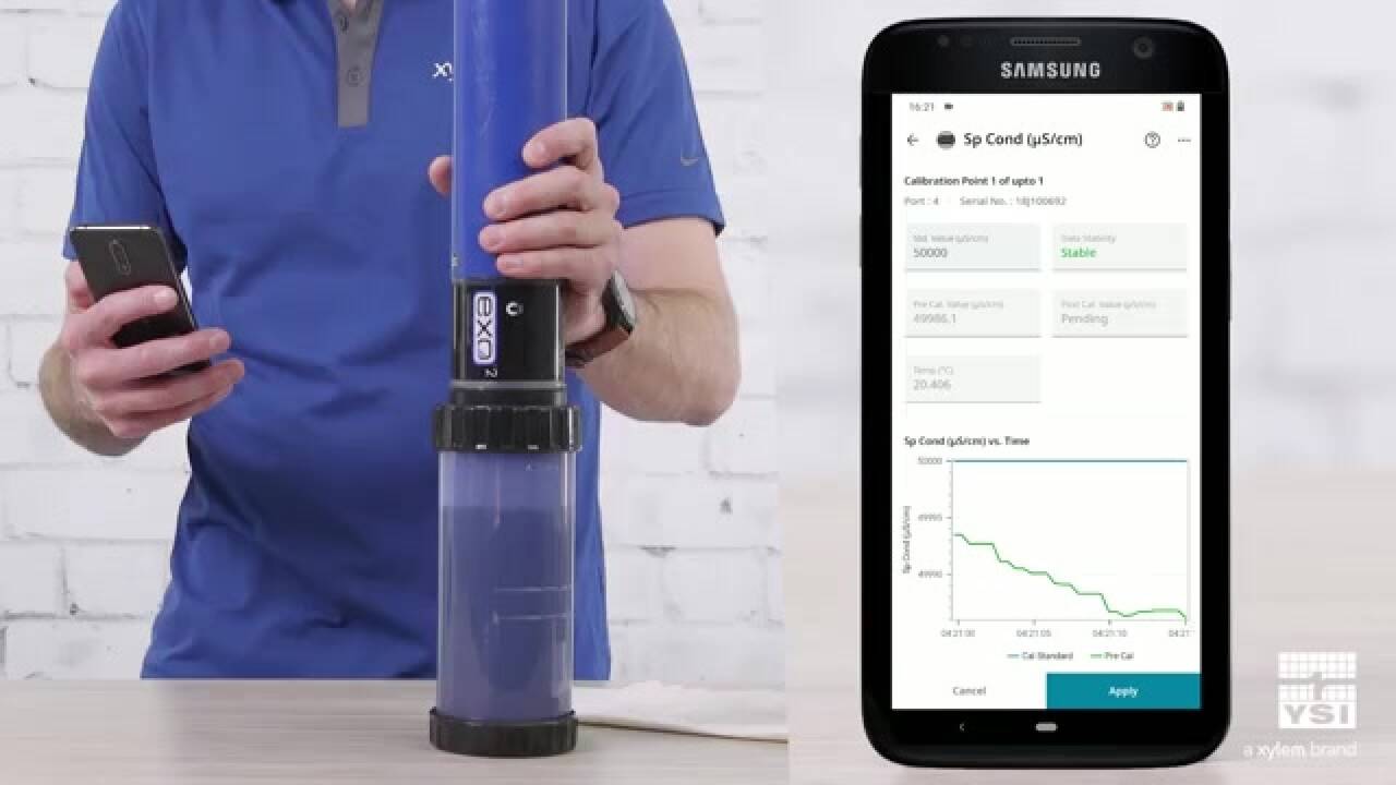 Person holding water quality monitoring device and smartphone