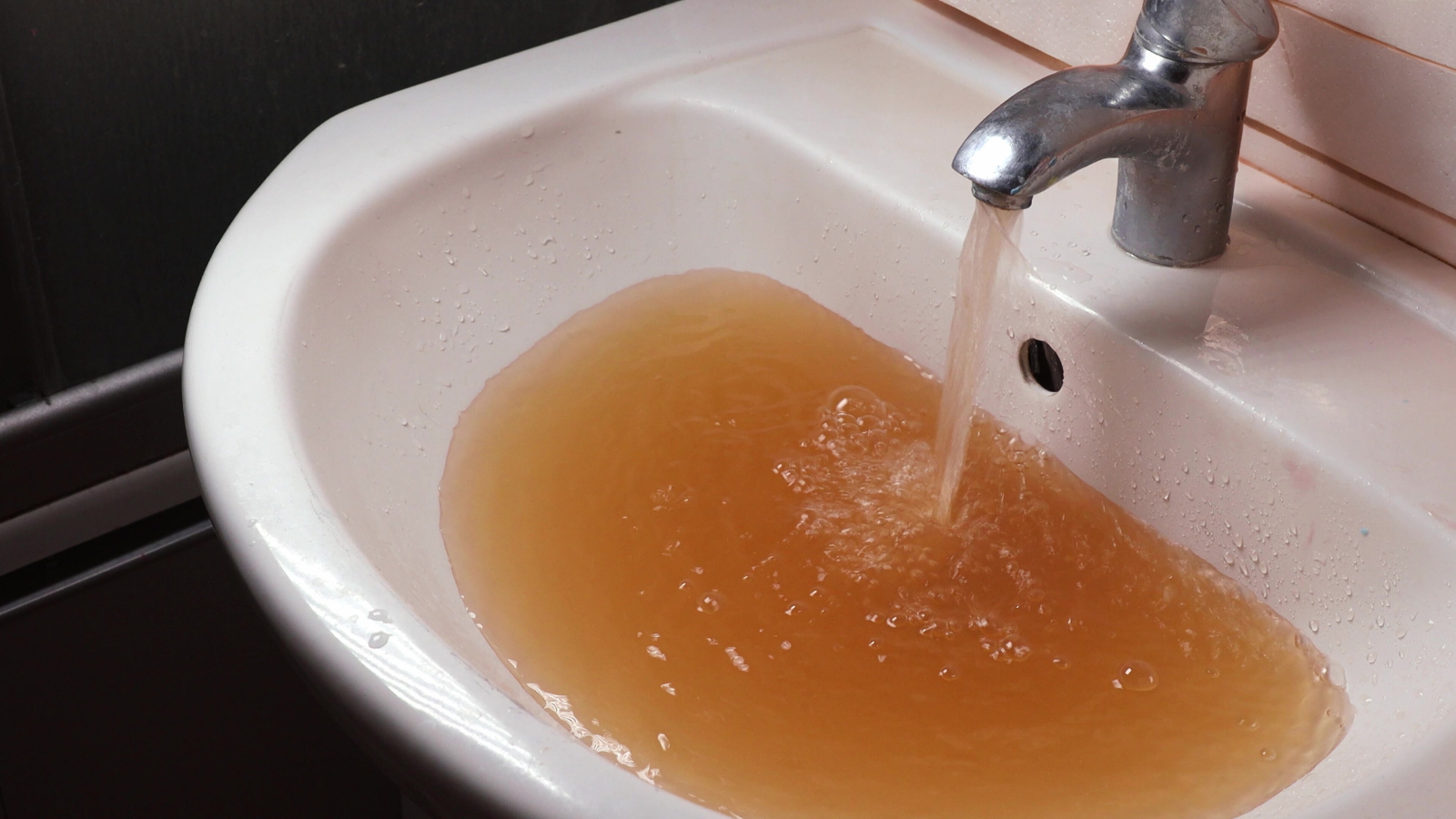 Bathroom sink with dirty, brownish water